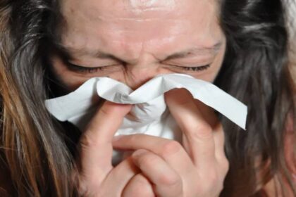 Kvinde der pudser næse i kleenex